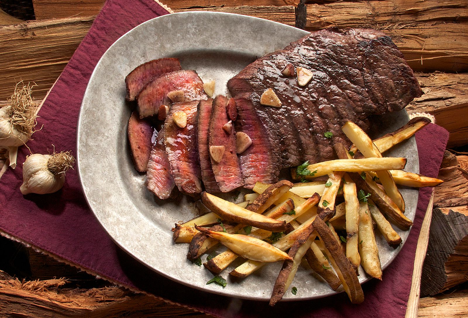 Entrecôte tranchée saignante, frites maison et ail rôti