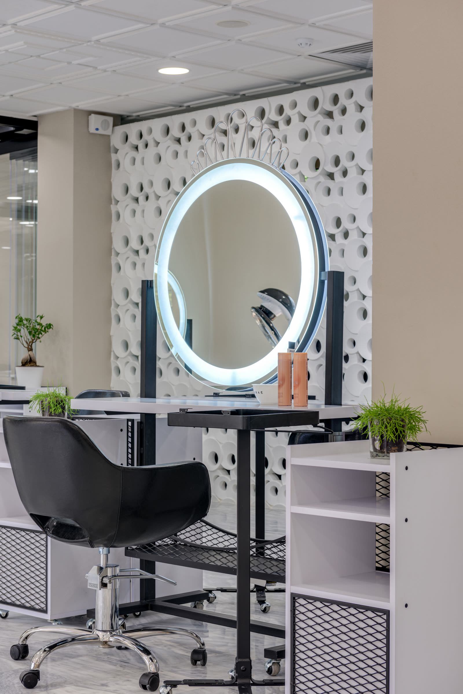 Postes de coiffage Beauty'Zen avec miroirs ronds lumineux et fauteuils dans un espace clair